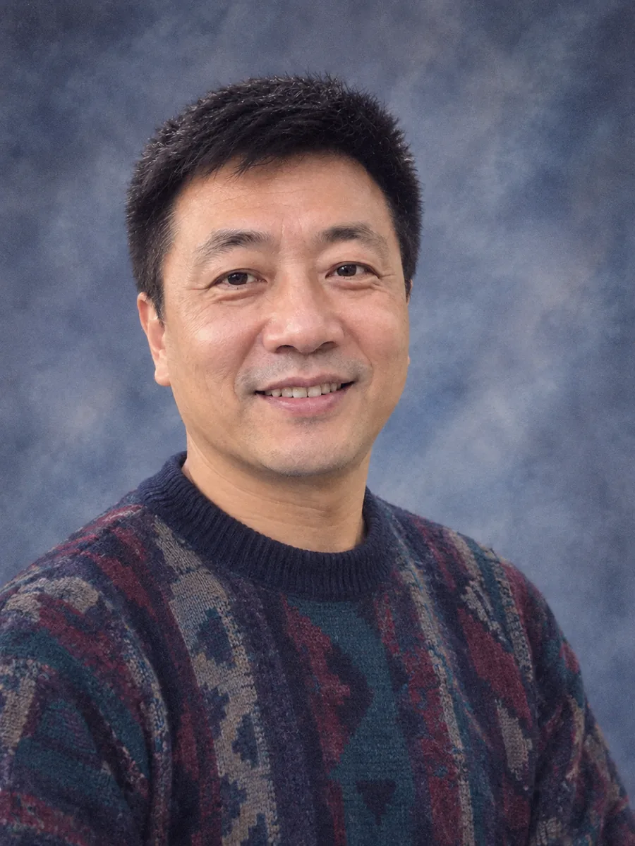 Portrait de classe années 90 d’un homme souriant en pull à motifs sur fond bleu marbré